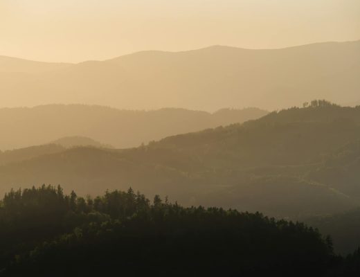 Capture the tranquil layers of Graz's rolling hills at sunset, radiating a peaceful ambiance.
