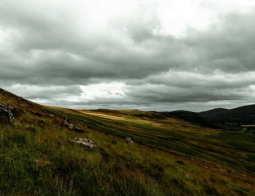 Scenic view of rolling hills and dramatic skies in the Scottish Highlands, UK.