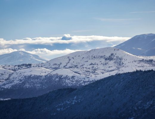 Breathtaking view of snow-capped mountains in winter under a clear blue sky.